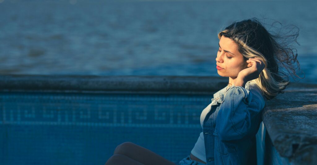 Young woman enjoying a serene moment by the water in Chascomús, Buenos Aires.